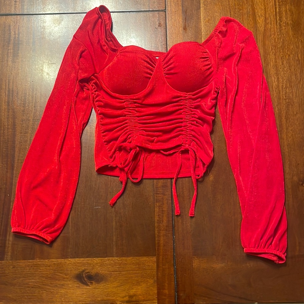 Red top with adjustable length, sheer flows sleeves.
